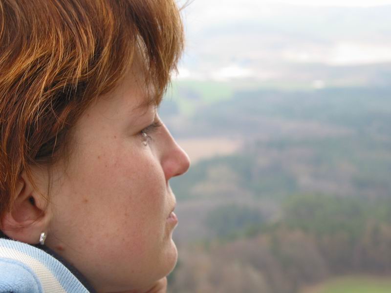 Holčička se slzou hledí do kraje